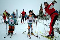 Na Jizerce se konaly první letošní závody v běhu na lyžích. Na snímku Jana Kareisová z Dukly Liberec (č. 1) a Jakub Serra ze Ski klubu Jablonec, kterým ukazuje cestu Michaela Cillerová. 
