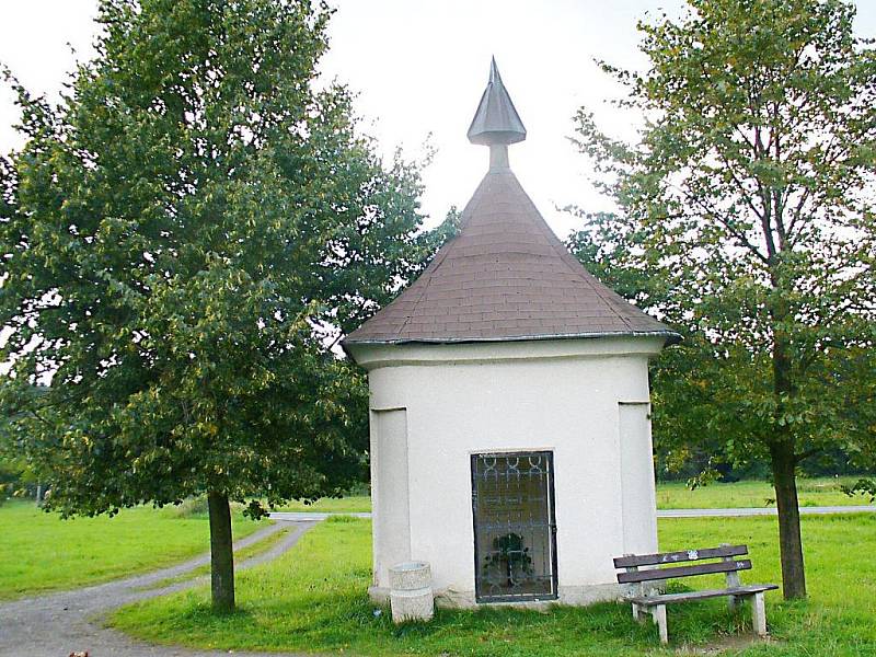 FOTO č. 1 Malý "domeček" zvoucí poutníka k zastavení, možná i k rozjímání a lavička k posezení. Co je to za objekt a kde se nachází?