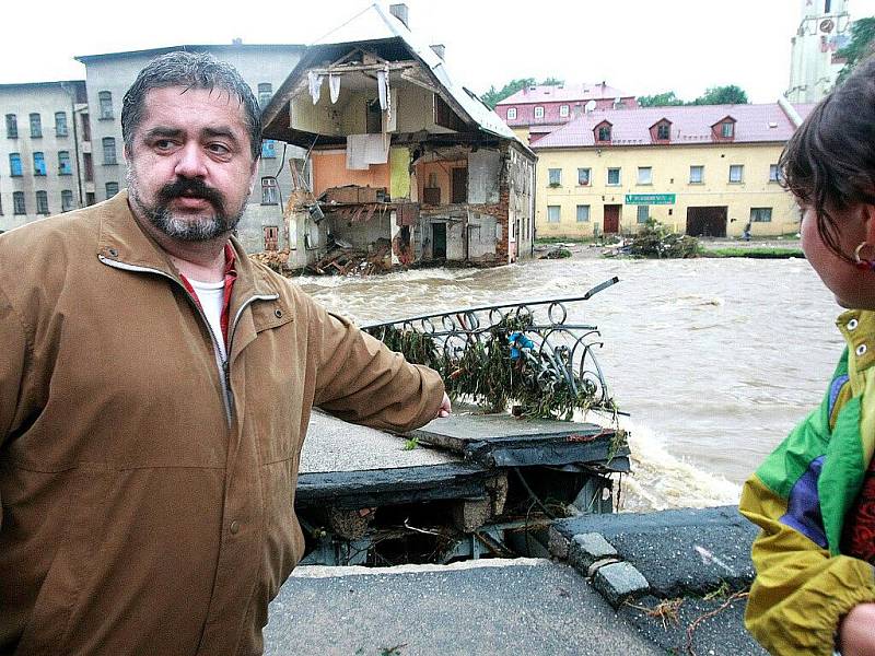 Chrastava v sobotu vpodvečer, krátce poté, co opadla nejvyšší voda. Obyvatelé a starosta M. Canov obhlížejí škody, mezi největší patří stržený most v centru města a zřícená polovina činžovního domu.