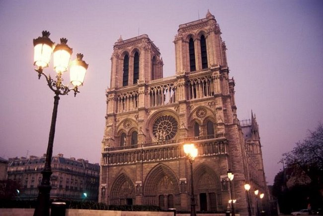 Notre Dame osvětlují za soumraku pouliční lampy.