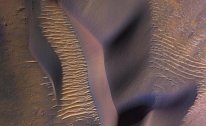 Sonda NASA Mars Reconnaisance Orbiter shlíží na svahy hory ve Valles Marineris, největším známém systému kaňonů ve sluneční soustavě. Napříč krajinou se vlní písečné duny posouvané marsovskými větry.
