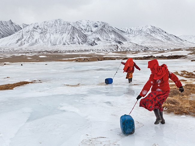 Kyrgyzské dívky vezou po ledu kanystry s vodou do rodinného tábora. Aby nabraly vodu, musely rozbít led na zamrzlém prameni. Muži mají na starosti stáda a obchod. 