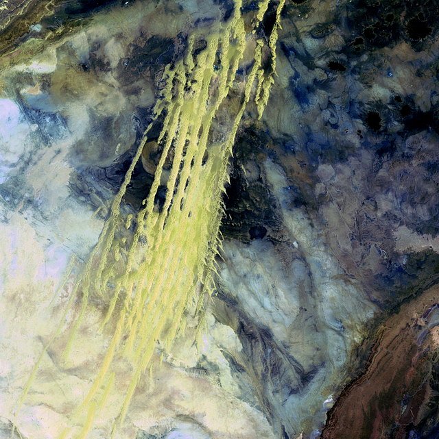 4.místo: Alžírské duny (8.dubna 1985)   Žluté pruhy táhnoucí se přes barevnou mozaiku jsou větrem naváté pískové duny. Tato oblast se nazývá Erg Iguidi a táhne se přes Alžírsko až do Mauretánie. Duny 