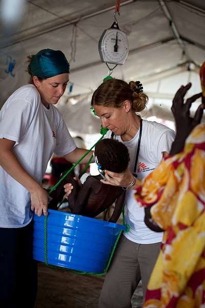 Zdravotní sestra Coleen Laginskie a lékařka Carolina Nandclares váží dvouletou Agash Tadey ve výživovém centru v nemocnici Lékařů bez hranic v táboře Batil.