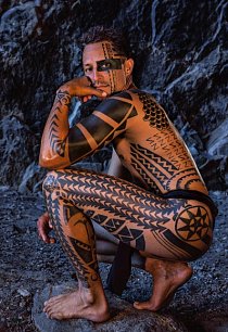 Stavební dělník Keli’iokalani Makua oblečený pouze do mala neboli bederní zástěrky. Ukazuje tradiční tetování, které vypráví jeho životní příběh. Tetování je populární znak havajské identity, ale na obličeji je vzácné.