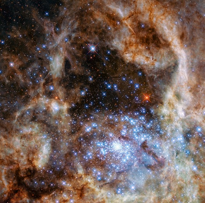 Fotografie ukazuje centrální oblast mlhoviny Tarantula ve Velkém Magellanově mračnu. Mladá a hustá hvězdokupa R136 je vidět v pravém dolním rohu. Obsahuje stovky mladých modrých hvězd, mezi nimi i ty největší, které se doposud podařilo ve vesmíru odhalit.