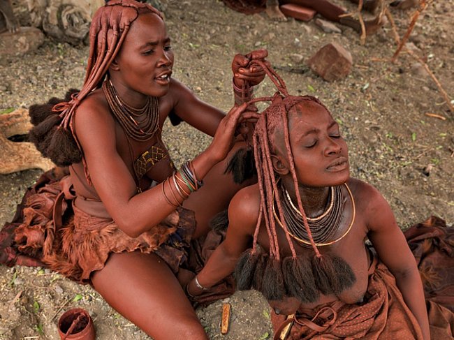 Na břehu řeky v severozápadní Namibii nanáší mladá žena z kmene Himba okr na vlasy druhé ženě. Okr je ceněný pro svůj teplý červený odstín a dnešní lidé jím zdobí své tělo se stejnou oblibou jako jejich pravěcí předkové.
