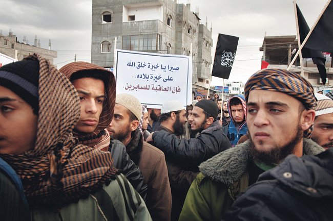 Plakát sděluje, že Alláh odmění ty, kteří jsou trpěliví. Mladí muži jsou salafističtí džihádisté a příslušníci radikálních odštěpeneckých skupin, které vyzývají k ozbrojenému boji proti nemuslimům. Sh