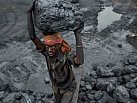 Důlní dělník Adžaj Maridžan nese kus uhlí z povrchového dolu v Bókapaharí ve státu Džhárkhand, aby jej naložil do čekajícího nákladního auta.