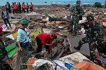 Lidé v indonéské provincii Lampung 23. prosince 2018 prohlížejí trosky po ničivém cunami. Stovky domů byly zničeny a desítky místních obyvatel zahynuly.