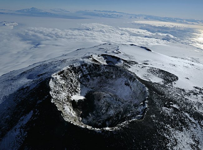Jednoho jasného večera je hlavní kráter sopky klidný a vypouští pouze několik obláčků páry. Sousedí s ním další, nyní už neaktivní kráter. Za ním se rozprostírá snová krajina tvořená mořským ledem a o