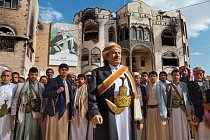 Významný jemenský kmenový vůdce šajch Sádik al-Ahmar má u sebe slavnostní dýku, když s příslušníky svého kmene stojí u svého sídla v San‘á nesoucího portrét jeho otce, který byl politikem. 