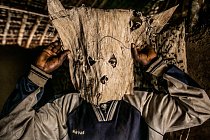 Lovec z malé vesnice v Demokratické republice Kongo si upravuje masku, kterou na sobě bude mít při sledování kořisti. Pojídání masa ze zvířat ulovených v lese je jednou z cest, jak se virus Ebola dostává do lidského organismu.