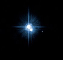 V roce 2006 přidal Hubbleův teleskop do sestavy Pluta dva malé měsíce: Nix a Hydru (nejvíce vpravo). Pluto má nyní pět známých měsíců, včetně svého velkého druha Charonu (vpravo od Pluta), a sonda New Horizons pátrá po dalších.
