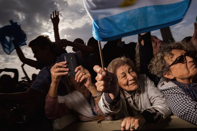 Nadšené poutnice s jásotem vítají blížícího se papeže. Jedna z žen drží vlajku papežovy rodné Argentiny. V roce 2013, kdy byl František zvolen, přijelo do Vatikánu třikrát více návštěvníků než předchozího roku. 