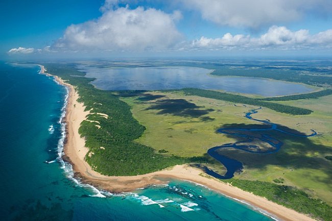Mozambické plány na výstavbu průmyslového přístavu v oblasti mořské rezervace Ponta do Ouro ohrožují některé z nejrozmanitějších korálových útesů u břehů jižní Afriky. Na leteckém snímku jsou útesy patrné jako tmavé stíny při pobřeží.