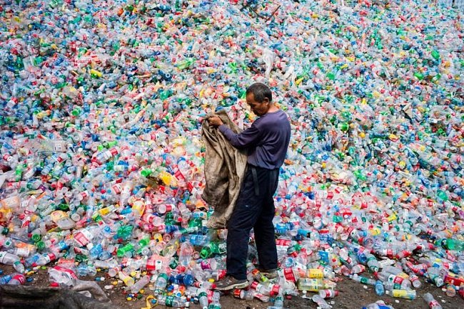 Čínský dělník třídí plastové lahve při recyklaci ve vesnici Dong Xiao Kou na okraji Pekingu.
