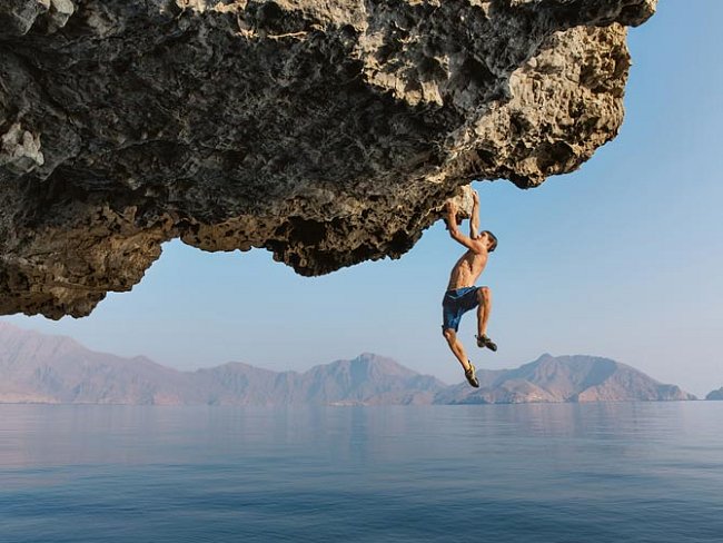 Honnold, odhodlaný dokončit novou trasu, visí na převisu. Poté, co se vytáhne, jak nejdál to na skále jde, se sólový lezec nad hlubokou vodou jednoduše pustí.