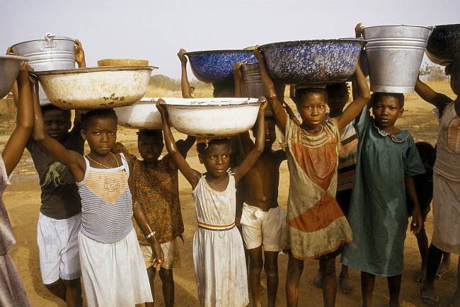 Vodu nosí ženy a výhradně v nádobách na hlavě (Ghana).