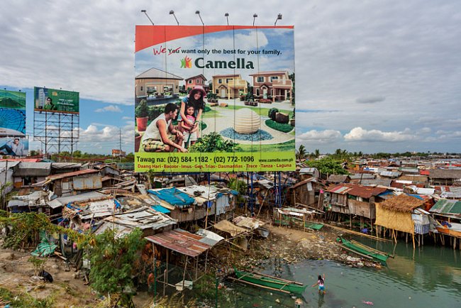 Billboard na Filipínách nabízí svůdnou představu. Internetové stránky developerské společnosti, která se zaměřuje na vracející se zahraniční dělníky, tvrdí, že dává Filipíncům „nejlepší důvod, proč se