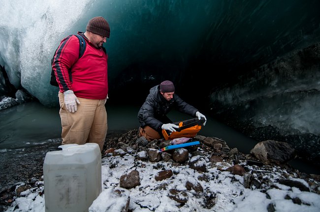 Mikrobiologové Markus Dieser a Erik Broemsen z Luissianské státní univerzity provádí odběry bakterií z potoku pramenícího pod ledovcem na Kótě 660. Nezbytnou součástí odběru vzorku tvoří měření chemic