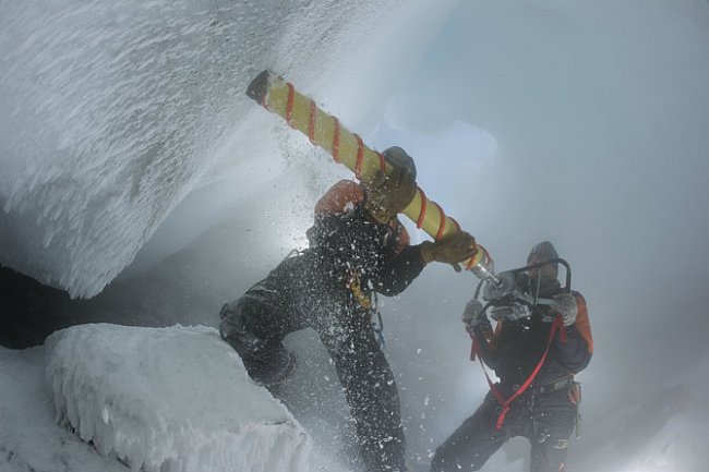 Stu Arnold z podpůrné výzkumné agentury Antarctica New Zealand přidržuje vrták, zatímco mikrobiolog Craig Cary vrtá do stěny ledové věže. O chvilku později se ozývají výkřiky nadšení: získali dokonalé