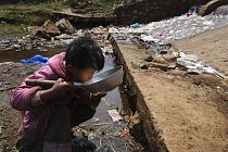 Dítě pije musí pít znečištěnou vodu v provincii Yunnan. V Číně se poukazuje na krizi pitné vody už léta. Překotný hospodářský rozvoj má za následek výrazné znečištění povrchových vod, které jsou hlavn