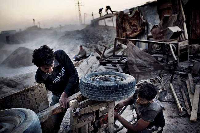 Obyvatelé Gazy opravují káru, aby mohli odvážet sutiny. Trosky zde zůstaly po izraelské operaci Lité olovo v letech 2008-2009. Akce byla zahájena jako reakce na pokračující raketové útoky z Gazy. Suti