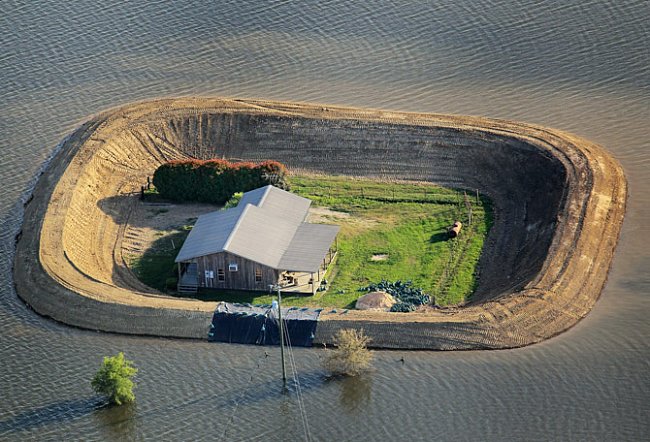 Mississippi. Dům nedaleko Vicksburgu, opevněný ochranným náspem, přežívá záplavu z rozvodněné řeky Yazoo v květnu 2011. 