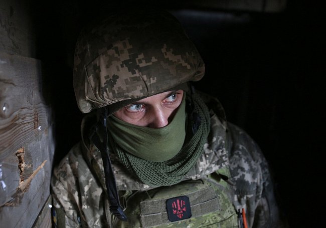 Ukrajinský voják čeká, až skončí minometný útok na frontě na východě Ukrajiny, kde jsou po vpádu ruských vojenských sil nasazeny početné vojenské oddíly.
