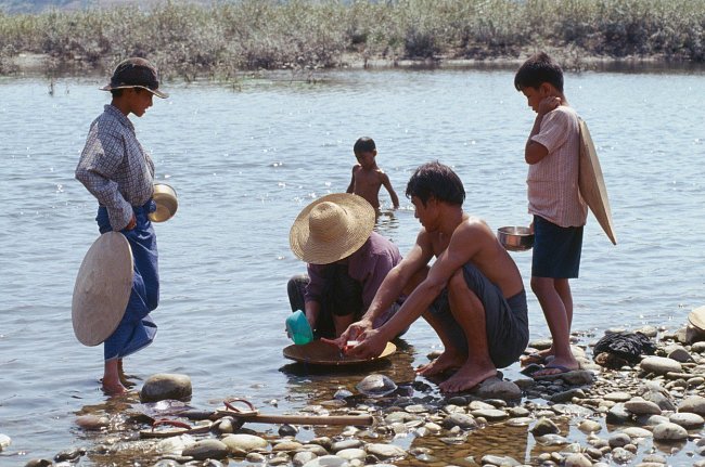 Stejně jako mladí muži u řeky Iravádí v Barmě stále se najde spoustu lidí, kteří se snaží zlato získat rýžováním.