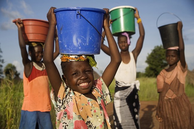 Senegalské dívky nosí vodu ze vzdálené studny.