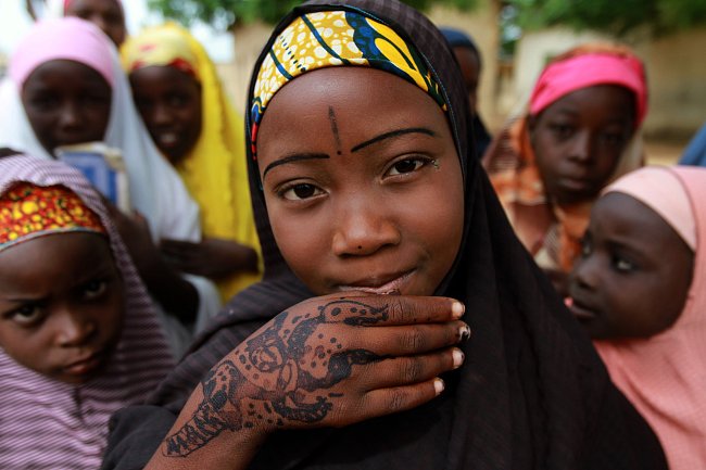 Dívka ukazuje ozdobené ruce během osalv v nigerijském městě Kano. 