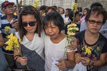 Evelyn (uprostřed) pláče na pohřbu své dcery Jessicy Cattiisové. Evelyn s rodinou ji vyprovodila žlutými květy a bílými balonky. Cattisová, která pracovala jako služka v Saudské Arábii, údajně spáchala sebevraždu. Její tělo bylo vráceno po 7 měsících.