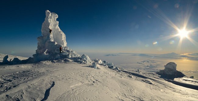 Je půlnoc, světlo je však stále jasné, a je proto těžké skončit se studiem ledových věží. Tato je největší na sopce Mt. Erebus, jenže tok tepla a vlhka zespodu pobořil její boční stěnu. V dálce, za da
