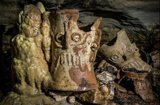 Během staletí narostly kolem rituálních předmětů krápníkové stalagmity, jak to můžeme vidět i u tohoto vykuřovadla na kopálovou pryskyřici, které zpodobuje boha deště Tlaloka.