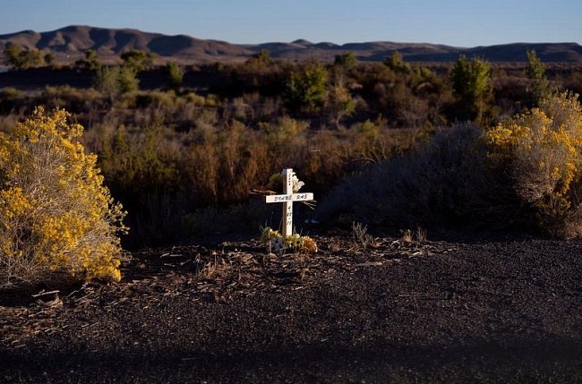 Osamělý bílý kříž na kraji silnice mezi Fallonem a Silver Springs v Nevadě.