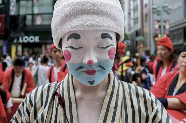 Japonsko: Žena oblečená jako čondara, tradiční klaun z japonského ostrova Okinawa, se účastní jedné z mnoha pouličních slavností v Tokiu.