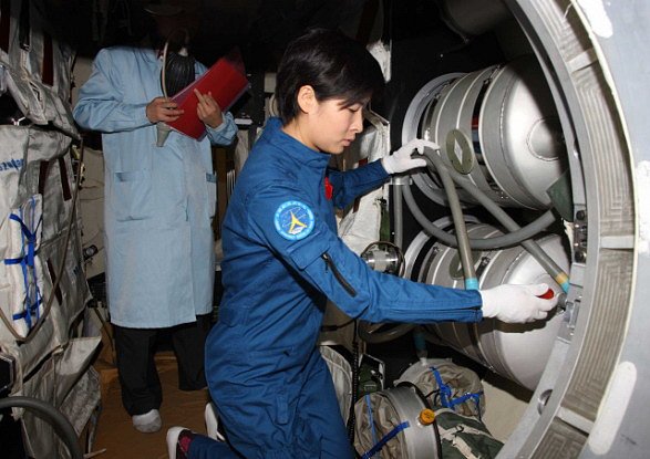 Na nedatované fotografii je Liu Yang kontroluje zařízení experimentálního modulu Tchien-kung 1.