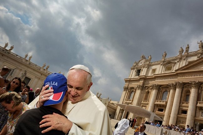 Papež František objímá zdravotně postiženého mladíka před bazilikou svatého Petra. Vůdce 1,2 miliardy křesťanů je obdivován pro svou vřelost, otevřenost a skromnost. 