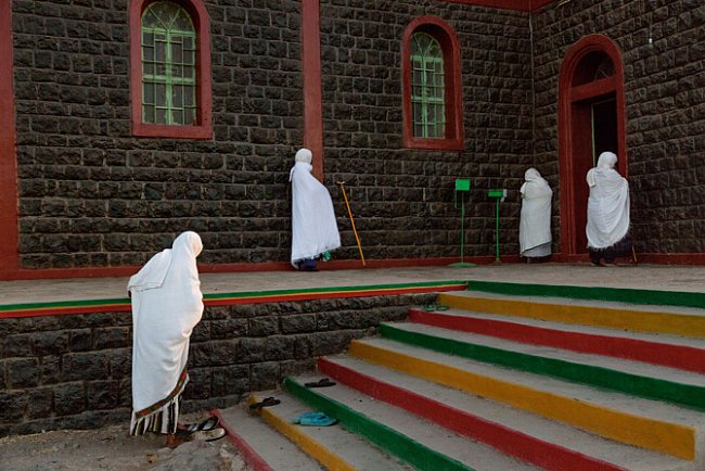 Ženy zahalené do bílých rouch symbolizujících čistotu jdou na modlitbu do kostela Etiopské ortodoxní církve v Asaitě. Pracovat na místních plantážích přichází stále více křesťanů z etiopské vrchoviny.