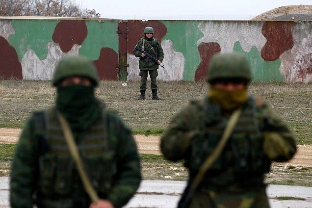 Ruští vojáci blokují cestu téměř dvěma stovkám příslušníků ukrajinských ozbrojených sil, když se 4. března 2014 přiblížili k vojenskému letišti nedaleko ruské námořní základny v Sevastopolu. Rusko Krym zabralo a připojilo ke svému území.