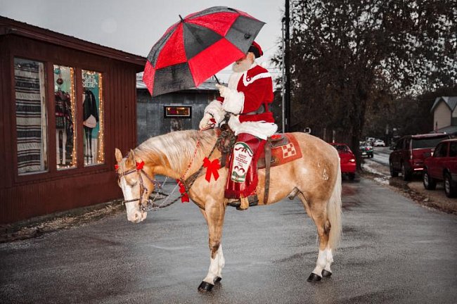 Kovboj Kringle pózuje v roce 2016 v historickém Gruene v Texasu, než se vydá na slavnostní jízdu městem, aby rozsvěcel vánoční osvětlení, mával místním dětem a rozdával jim cukroví.