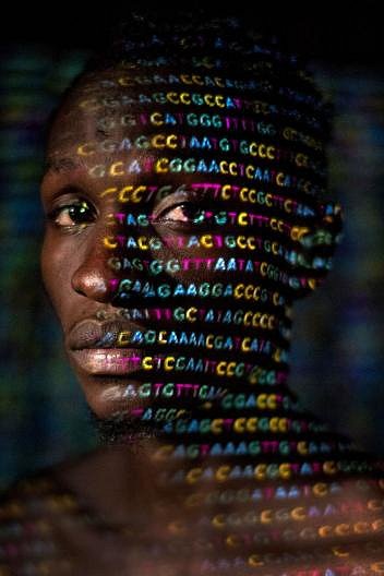 Na tvář Uganďana Ryana Lingarminllara se promítají čtyři písmena genetického kódu – A, C, G a T. DNA odhaluje to, co barva pleti zastírá: všichni máme africké předky.