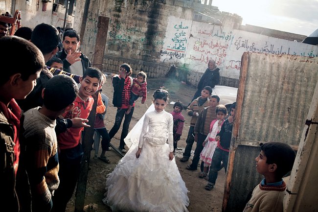 Beduínská svatba ve vesnici Al-Maslach jižně od Gazy: dvanáctiletá prodavačka květin Hasna Abú Wakíd se řadí do průvodu, který ji doprovodí k ženichovu domu. Svatby jsou dodnes slavnostní veřejné udál