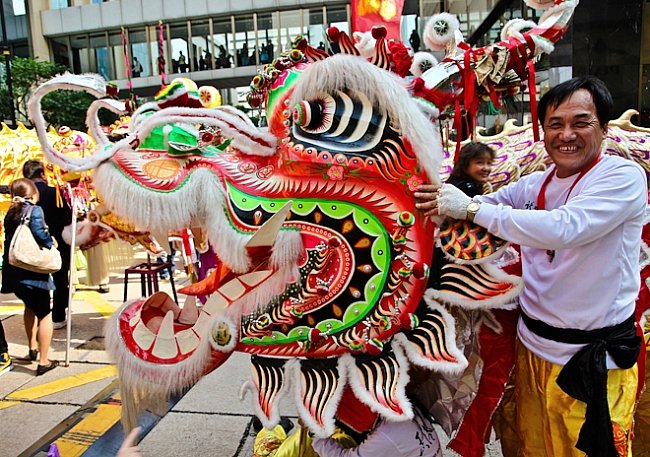 Lidé se srocují kolem místa, odkud mají  do Centralu  vyrazit Draci a Lvi, kteří  jsou předvojem  oslav nadcházejícího čínského Roku draka. 