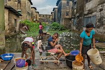 Dívky myjí nádobí a vaří burské oříšky (nahoře) na prodej. Pracují v chátrajícím obytném komplexu, jednom z mnoha okrsků laciného bydlení, levně postavených vládou státu Lagos před více než třemi desítkami let.
