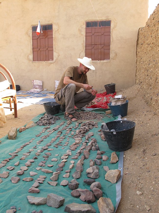 Zpracovávání kamenných artefaktů na základně ve vesnici Al Hudžér Abú Dóm, pohoří Sabaloka, výzkumy ČEgÚ.
