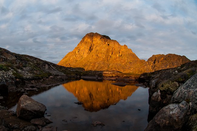 Poslední večerní paprsky osvěcují monumentální horu Nasaasaaq (784 m.n.m.), nedaleko přímořského města Sisimiut, které představuje se svými pět a půl tisíci obyvateli druhé největší grónské město. 