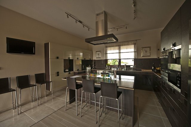 Kuchyně s barovým pultem je vysoce moderní, praktická a prostorná. 
